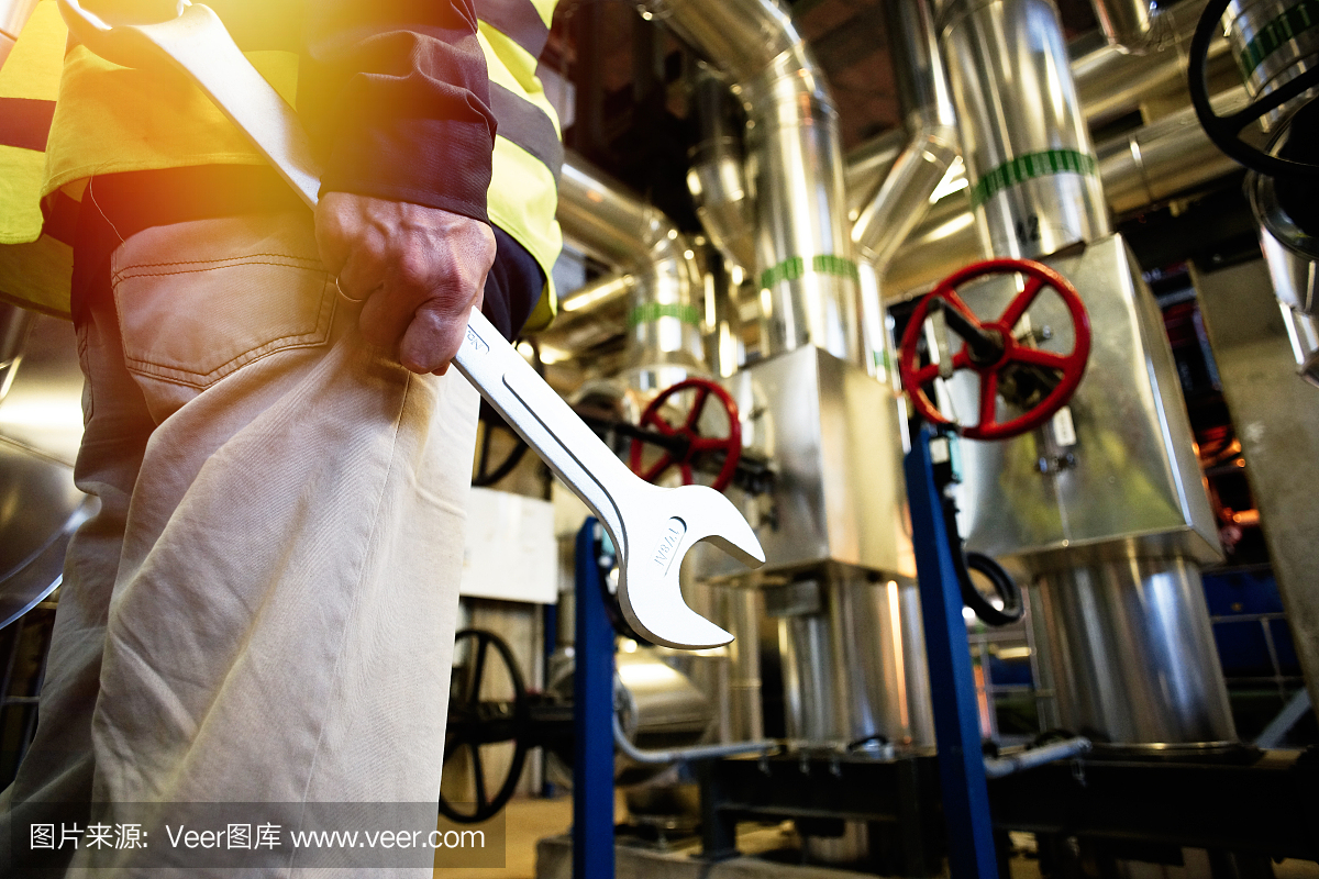 工業(yè)工人在工廠車間用扳手工作